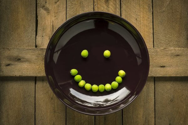 A picture of a smiley face made of peas, can emojis encourage children to make healthy eating choices, Be Curious