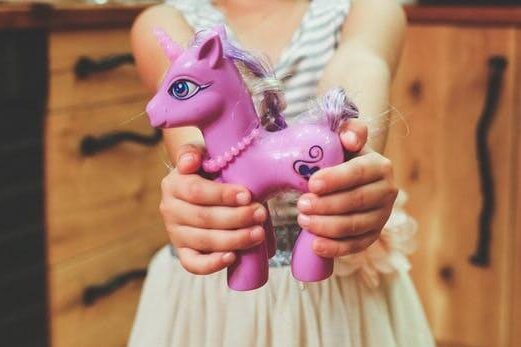 Picture of a girl holding a pink unicorn, are gender specific toys causing stereotypes in education and the work place?, Be Curious